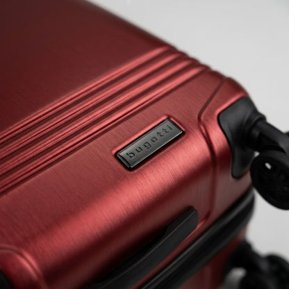 Macro detail of a red Bugatti Nashville carry-on luggage shell with brushed texture and logo badge.