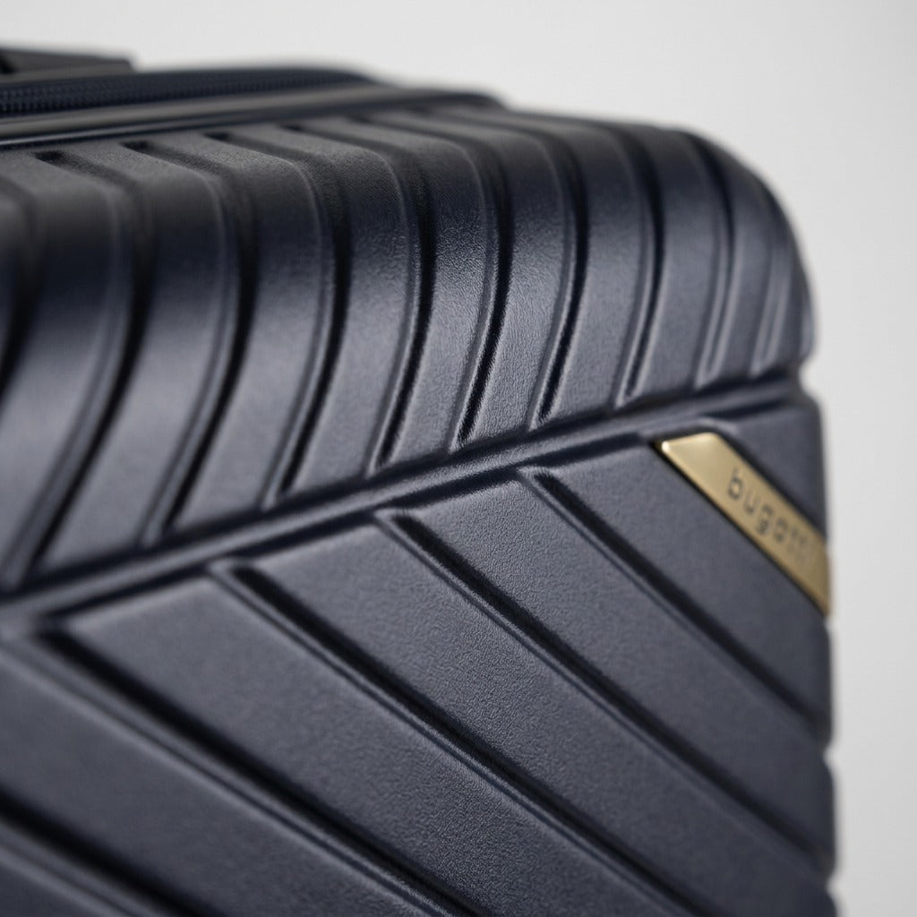 Macro detail of the navy polycarbonate shell on a Bugatti Oslo luggage, showing textured ridges.
