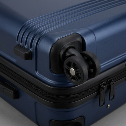 Macro detail of Bugatti Nashville navy luggage showing 360-degree spinner wheels and ribbed shell.