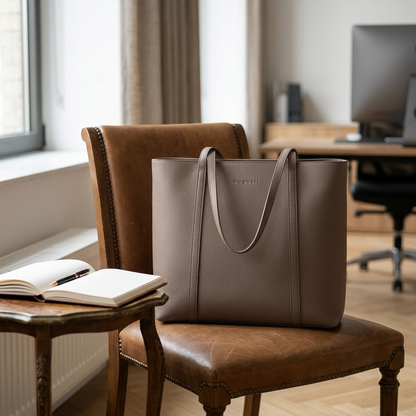 Bugatti Pure Business taupe leather tote bag resting on a leather armchair in a contemporary office context.
