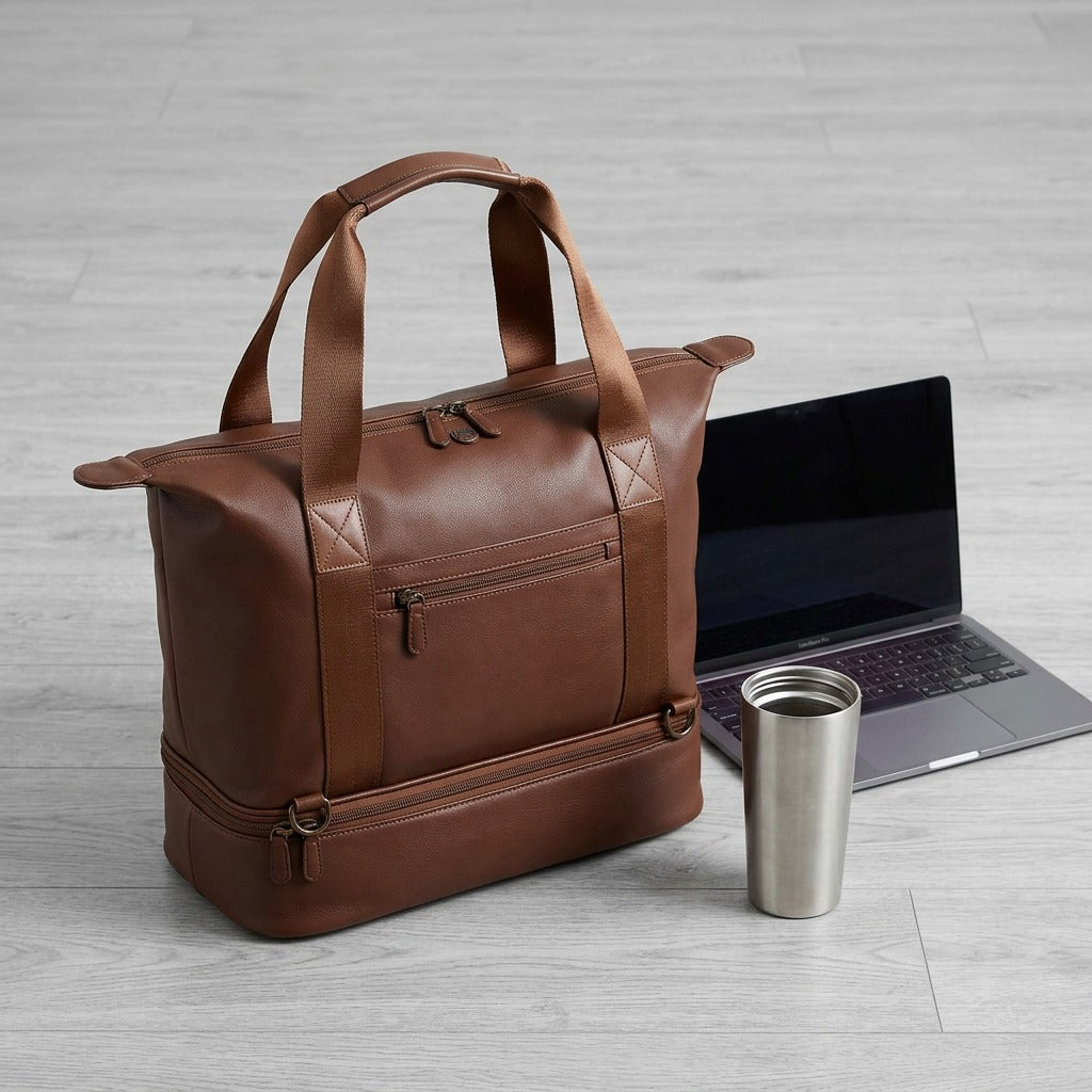 Brown Bugatti Raphael 4-in-1 tote bag shown for scale beside a laptop and a stainless steel tumbler.