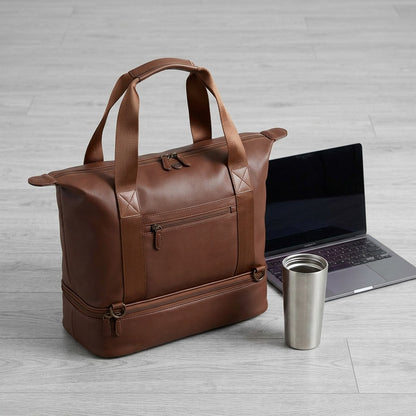 Brown Bugatti Raphael 4-in-1 tote bag shown for scale beside a laptop and a stainless steel tumbler.