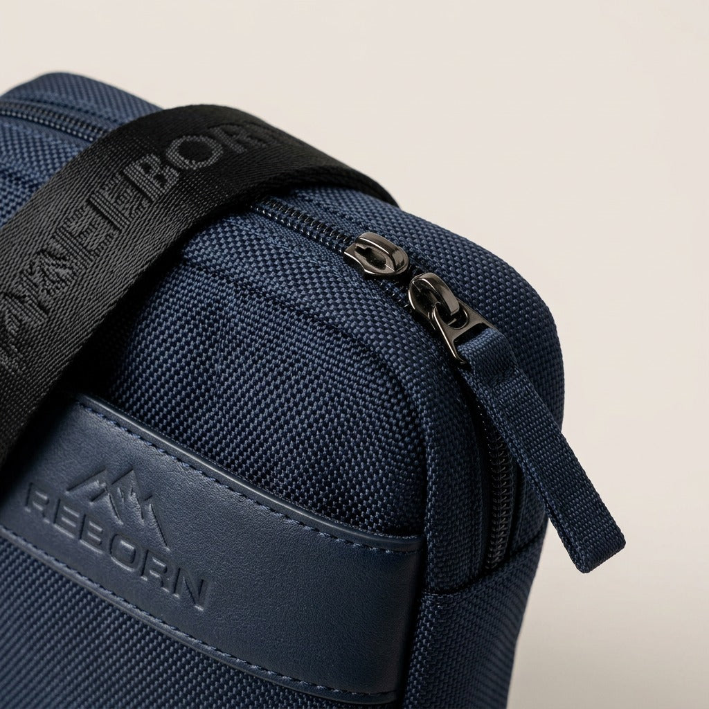 Macro detail of the Bugatti Reborn navy crossbody bag showing woven RPET fabric and metal zipper.