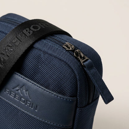 Macro detail of the Bugatti Reborn navy crossbody bag showing woven RPET fabric and metal zipper.