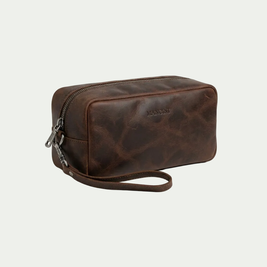 Mancini Buffalo Leather Toiletry Kit in brown with top zipper and wrist strap on white background.