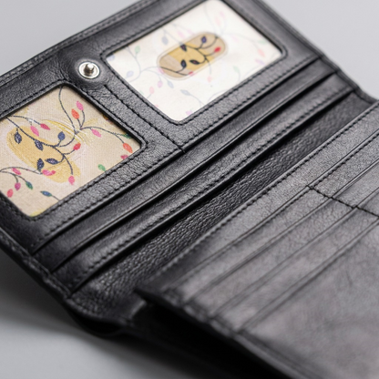 Close-up of the Mancini Casablanca black leather trifold wallet showing ID windows and card slots.