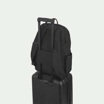 Bugatti Madison backpack in black, secured to a suitcase handle with the rear luggage strap