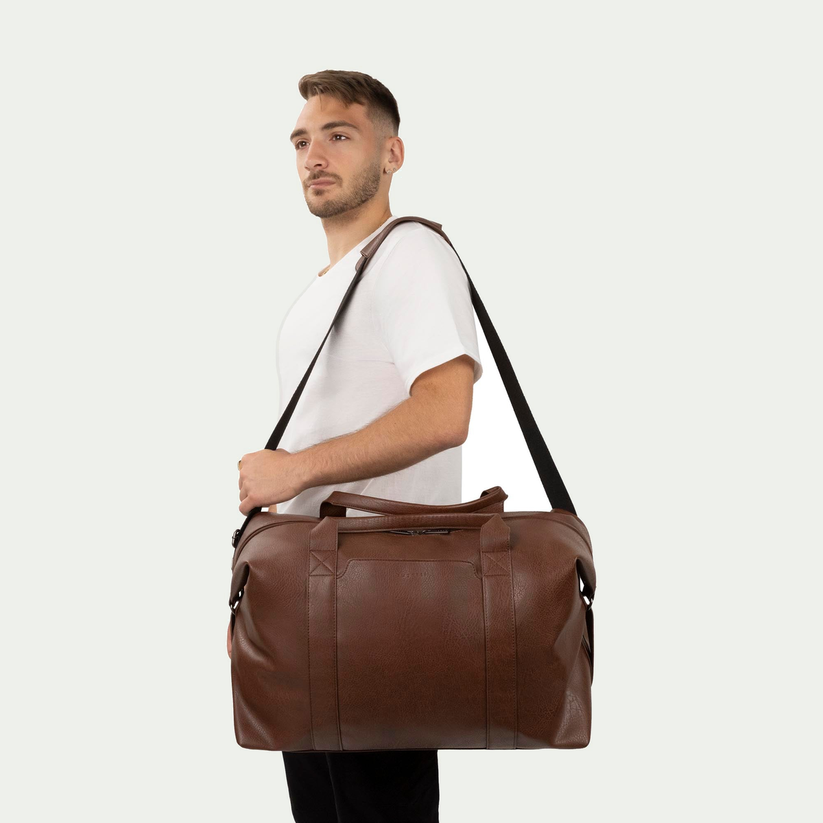Bugatti Palermo duffle bag in cognac, carried on a model’s shoulder