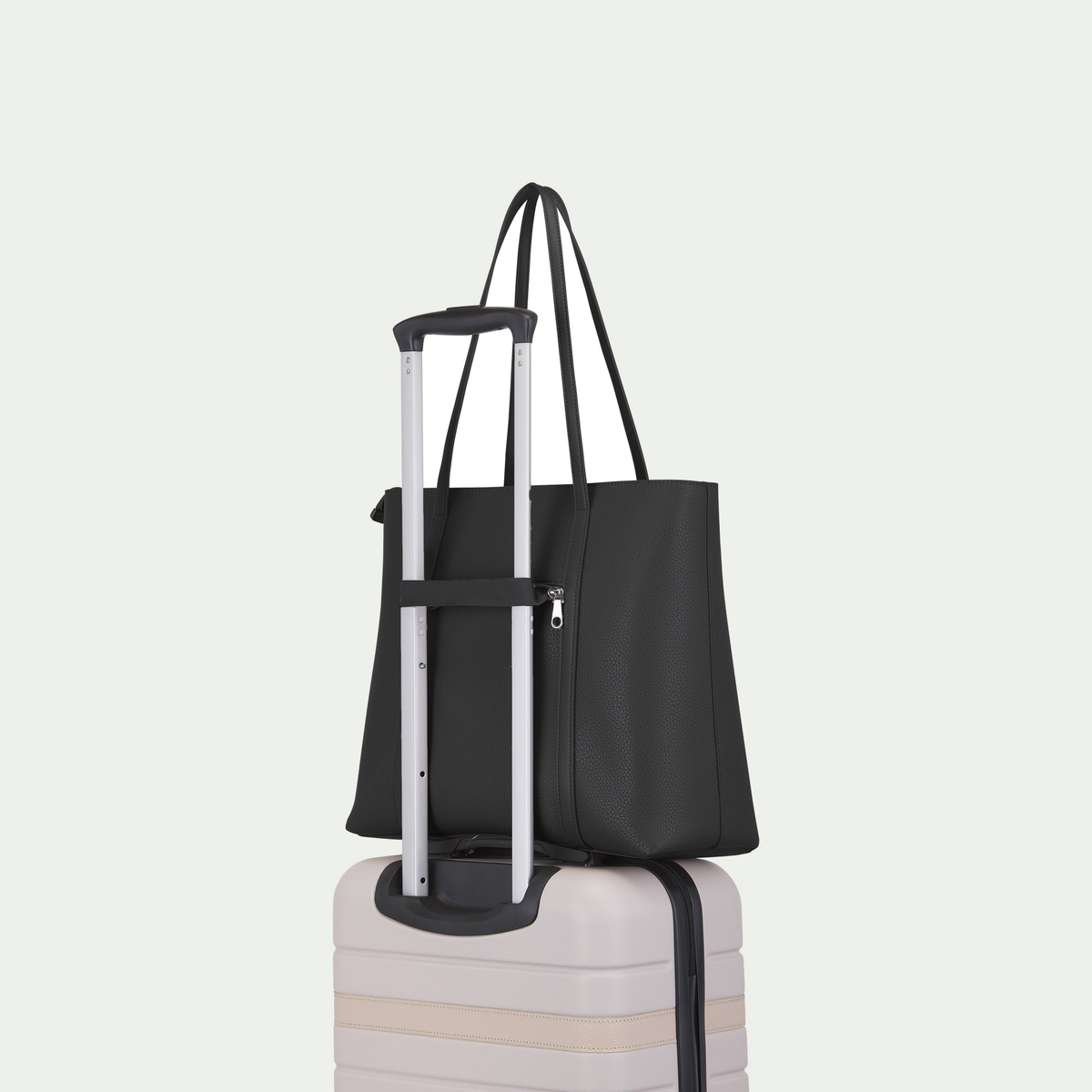 Cabas d’affaires Bugatti Pure couleur noire (Black), fixé à une poignée de valise par la sangle arrière