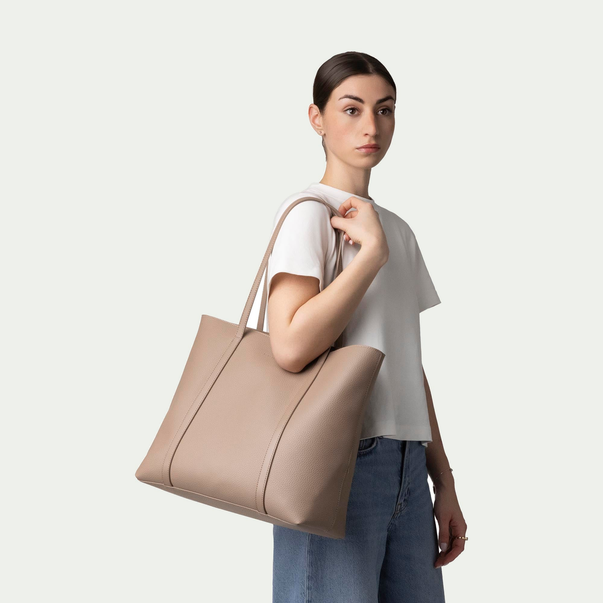 Cabas d’affaires Bugatti Pure couleur taupe, porté à l’épaule par un modèle